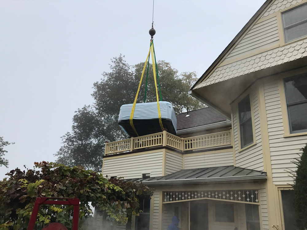 Crane lifting spa onto a 2 story deck